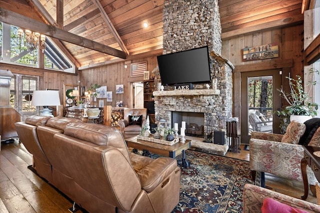 living room with wood walls, a wealth of natural light, wood finished floors, and beamed ceiling