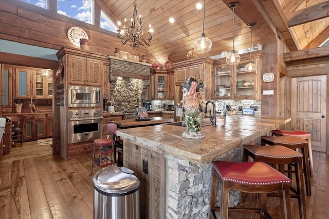 kitchen featuring glass insert cabinets, wood ceiling, appliances with stainless steel finishes, and hanging light fixtures