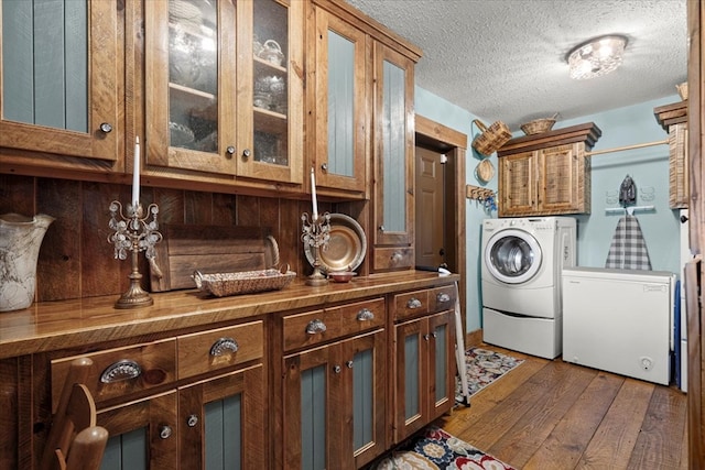 laundry area featuring dark wood-style floors, washer and dryer, and a textured ceiling