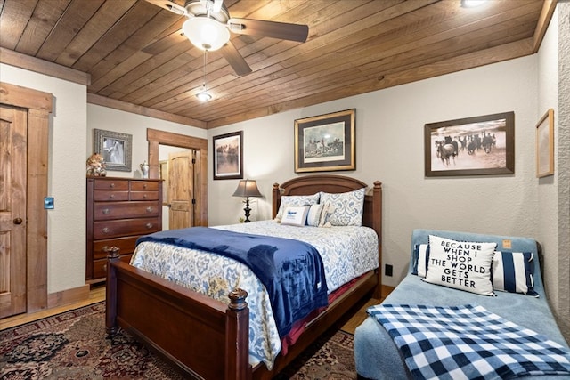 bedroom featuring a textured wall, wooden ceiling, and a ceiling fan