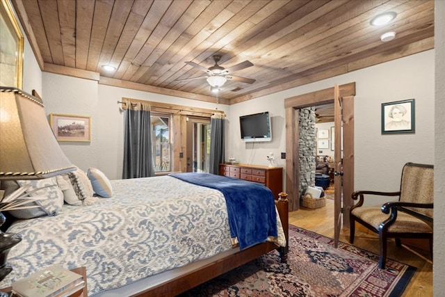 bedroom featuring wooden ceiling, ceiling fan, wood finished floors, and a textured wall