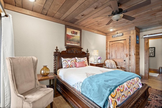 bedroom featuring wood finished floors, wood ceiling, and a ceiling fan