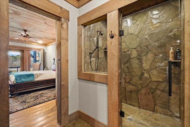 ensuite bathroom featuring a marble finish shower, baseboards, a ceiling fan, wood finished floors, and ensuite bathroom