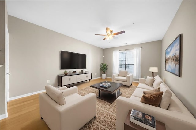 living room with light hardwood / wood-style flooring and ceiling fan