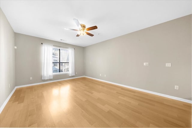 empty room with ceiling fan and light wood-type flooring