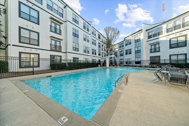 view of swimming pool featuring pool water feature and a patio