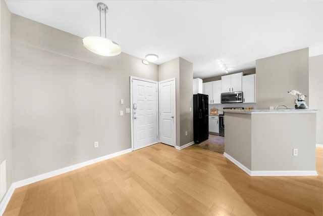 kitchen featuring white cabinetry, appliances with stainless steel finishes, kitchen peninsula, pendant lighting, and light hardwood / wood-style floors