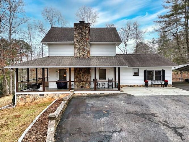 farmhouse inspired home featuring a carport and covered porch