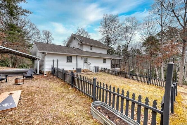 rear view of house featuring a yard and central air condition unit