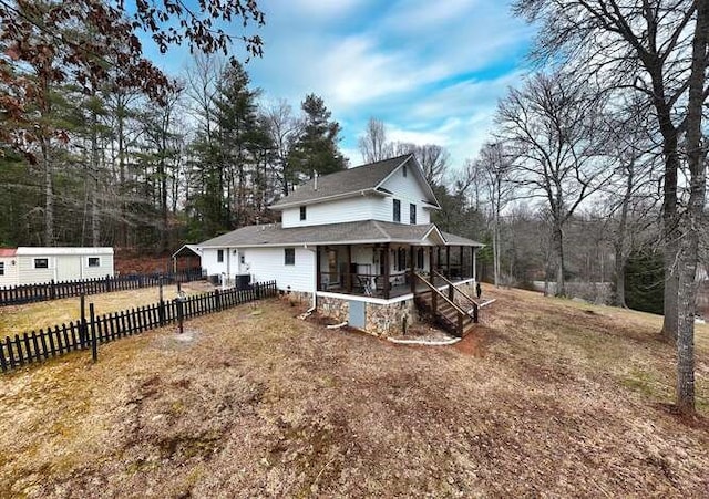 view of front of home featuring a sunroom and a front lawn