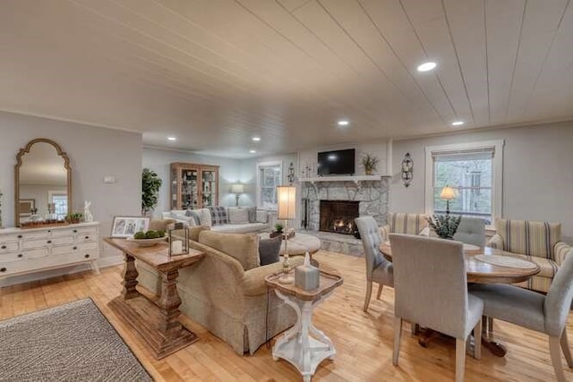 living room with wood ceiling, a fireplace, and light hardwood / wood-style floors