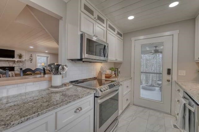 kitchen featuring tasteful backsplash, wood ceiling, stainless steel appliances, light stone countertops, and white cabinets