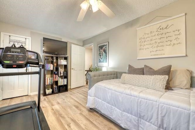 bedroom with ceiling fan, a textured ceiling, and light wood-type flooring