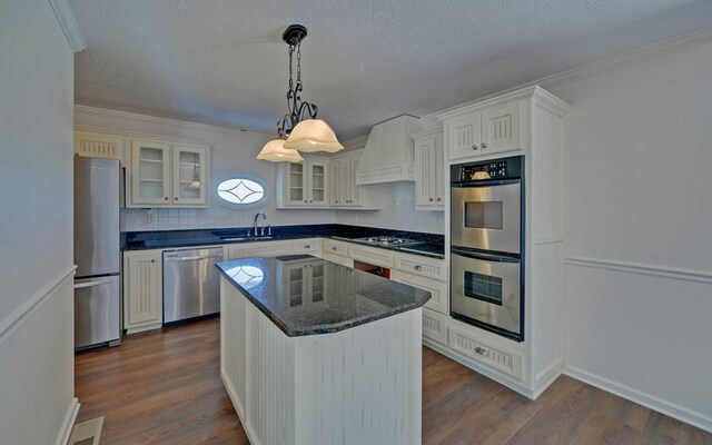 kitchen featuring white cabinets, a kitchen island, stainless steel appliances, custom range hood, and dark hardwood / wood-style flooring