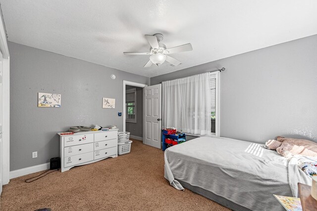 bedroom featuring multiple windows, ceiling fan, and light colored carpet