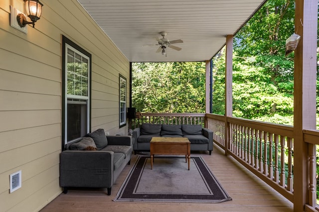 wooden terrace featuring ceiling fan and an outdoor living space