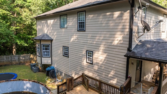 back of house with a yard, cooling unit, and a deck