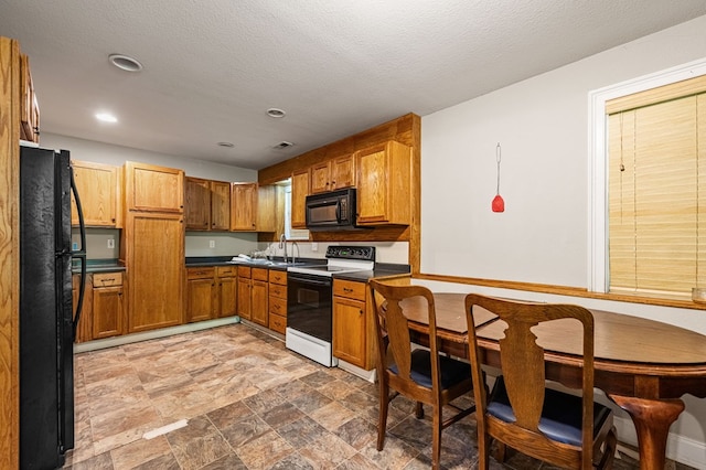 kitchen featuring sink, a textured ceiling, and black appliances