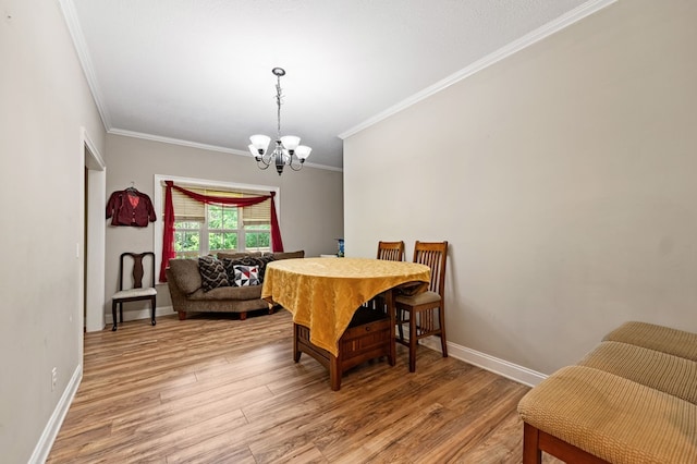 dining space featuring ornamental molding, a chandelier, and hardwood / wood-style flooring