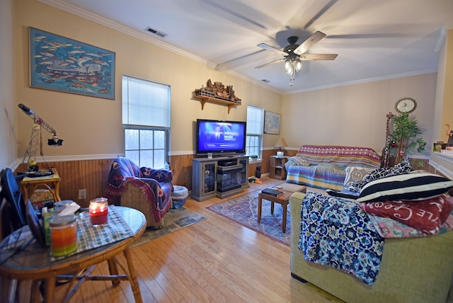 living room featuring hardwood / wood-style floors, crown molding, and ceiling fan