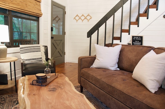 living room with hardwood / wood-style floors and wood walls