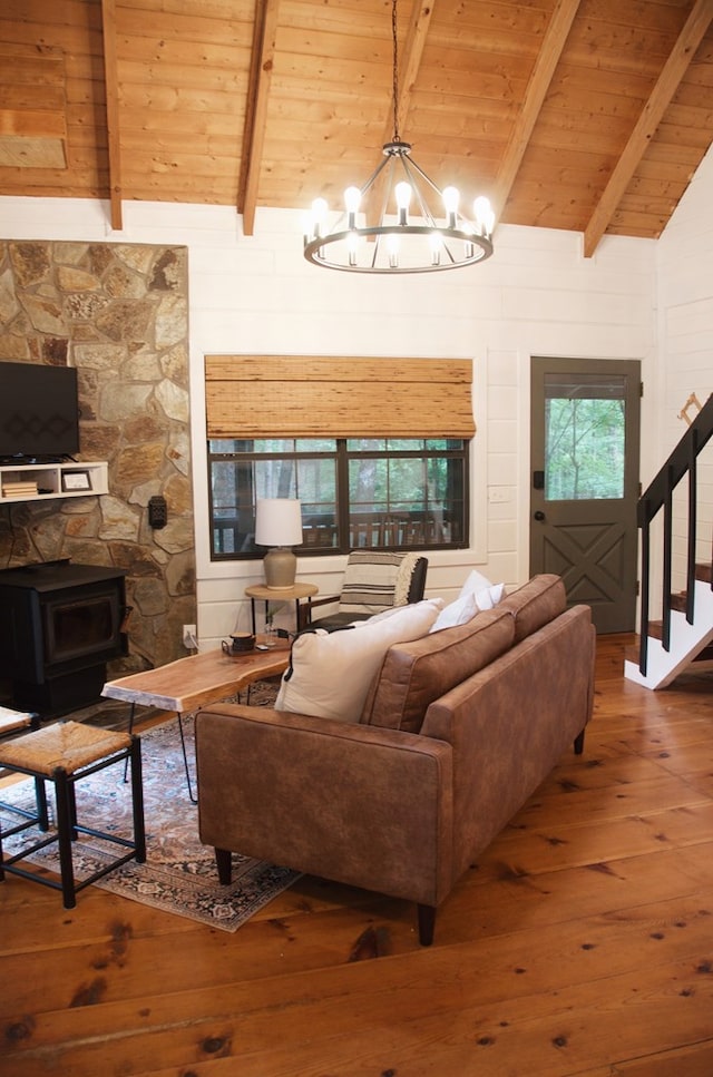 living room with a wood stove, wooden ceiling, vaulted ceiling with beams, a chandelier, and wood-type flooring