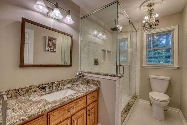 bathroom featuring vanity, a shower with shower door, a chandelier, tile patterned floors, and toilet