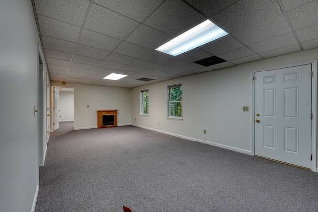 basement with a paneled ceiling and carpet flooring