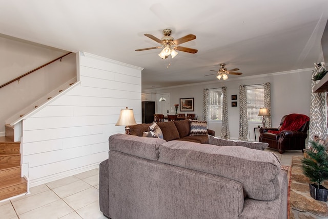 living room with light tile patterned flooring, crown molding, stairs, and ceiling fan