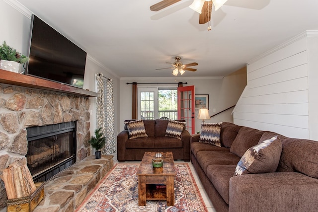 living room featuring crown molding, a fireplace, and ceiling fan