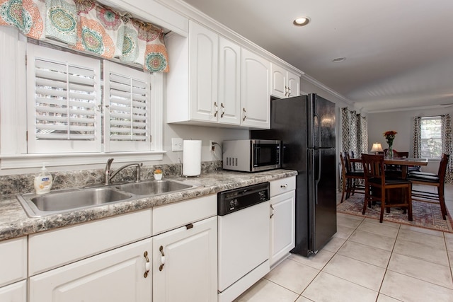 kitchen featuring light tile patterned flooring, white dishwasher, a sink, white cabinetry, and stainless steel microwave