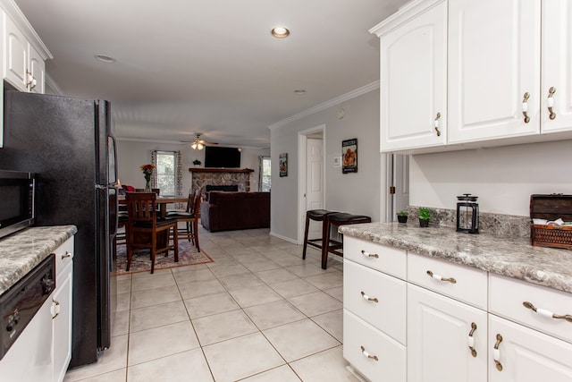 kitchen featuring light tile patterned floors, a fireplace, ceiling fan, ornamental molding, and stainless steel appliances