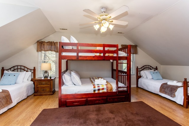 bedroom with vaulted ceiling, visible vents, ceiling fan, and wood finished floors