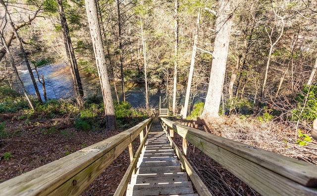 surrounding community featuring a water view and a wooded view