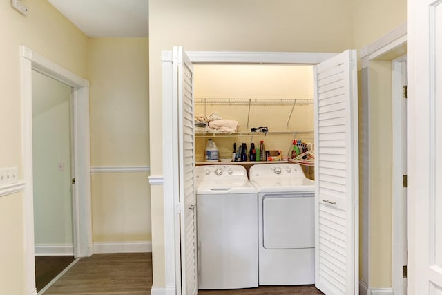 laundry room featuring laundry area, wood finished floors, separate washer and dryer, and baseboards