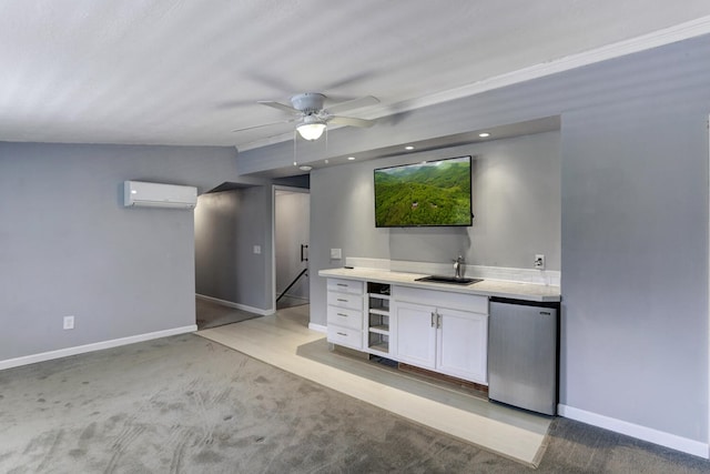 kitchen featuring ceiling fan, white cabinets, refrigerator, a wall mounted AC, and a sink