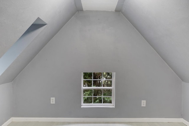 additional living space featuring baseboards, lofted ceiling, and wood finished floors