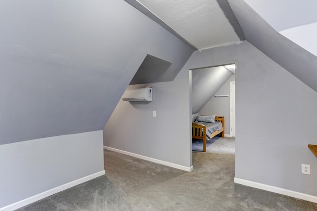 additional living space with lofted ceiling, a wall unit AC, baseboards, and carpet floors