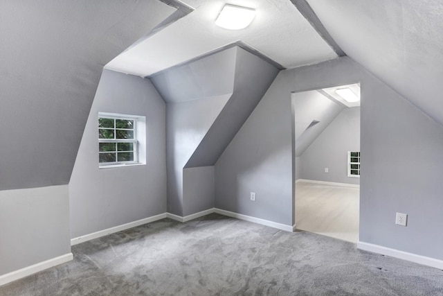 bonus room with vaulted ceiling, carpet, and baseboards