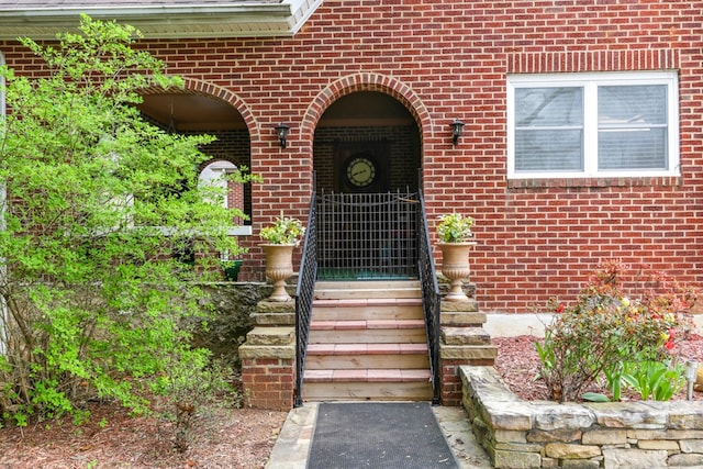 doorway to property featuring brick siding