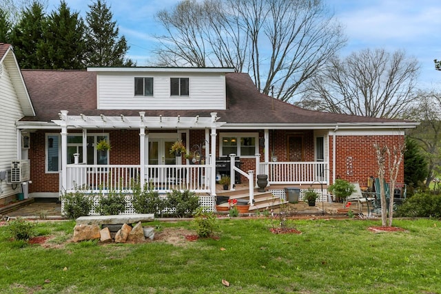 view of front of house featuring a porch, brick siding, a pergola, and a front lawn