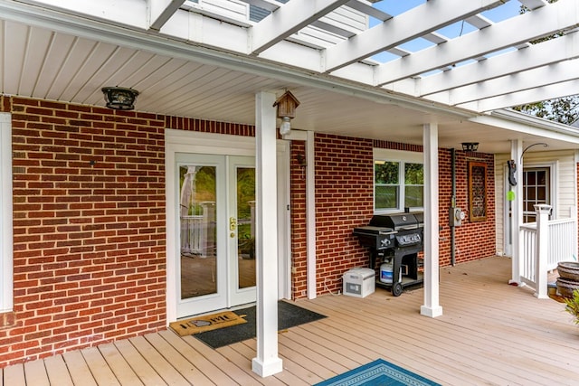 wooden deck with french doors, a pergola, and grilling area