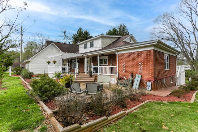 view of front of house featuring a front yard, covered porch, and brick siding