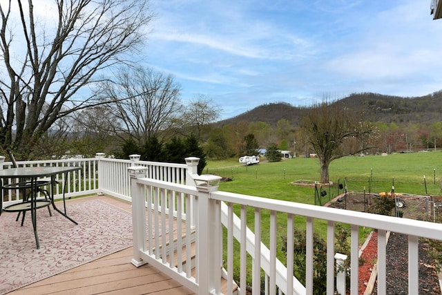 wooden terrace featuring a mountain view and a yard