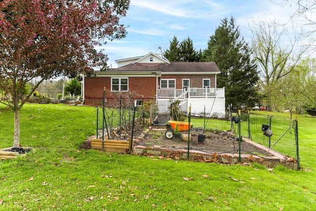 back of house featuring a yard, brick siding, and a vegetable garden