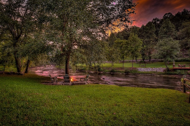 view of community featuring a fire pit and a lawn