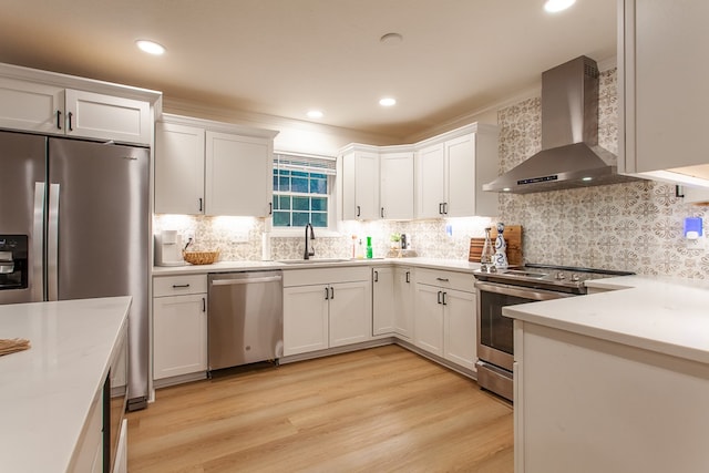 68 Phillips Crk, Andrews, NC 28901 - kitchen featuring appliances with stainless steel finishes, wall chimney exhaust hood, a sink, white cabinets, and light wood-style floors