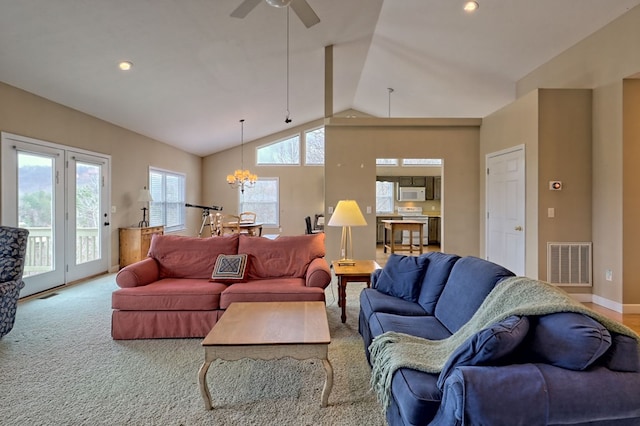 living room with carpet flooring, ceiling fan with notable chandelier, and lofted ceiling