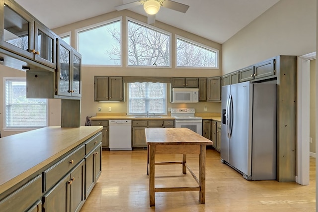 kitchen featuring ceiling fan, sink, high vaulted ceiling, light hardwood / wood-style floors, and white appliances