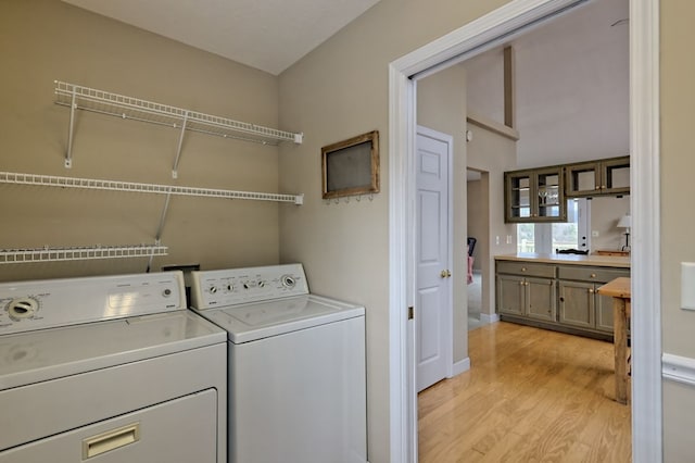 laundry room featuring separate washer and dryer and light hardwood / wood-style flooring